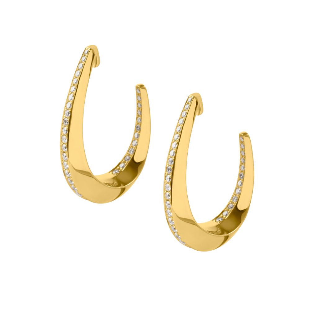 A pair of gold crescent-shaped hoop earrings with a row of small clear stones along the front edge, set against a plain white background.