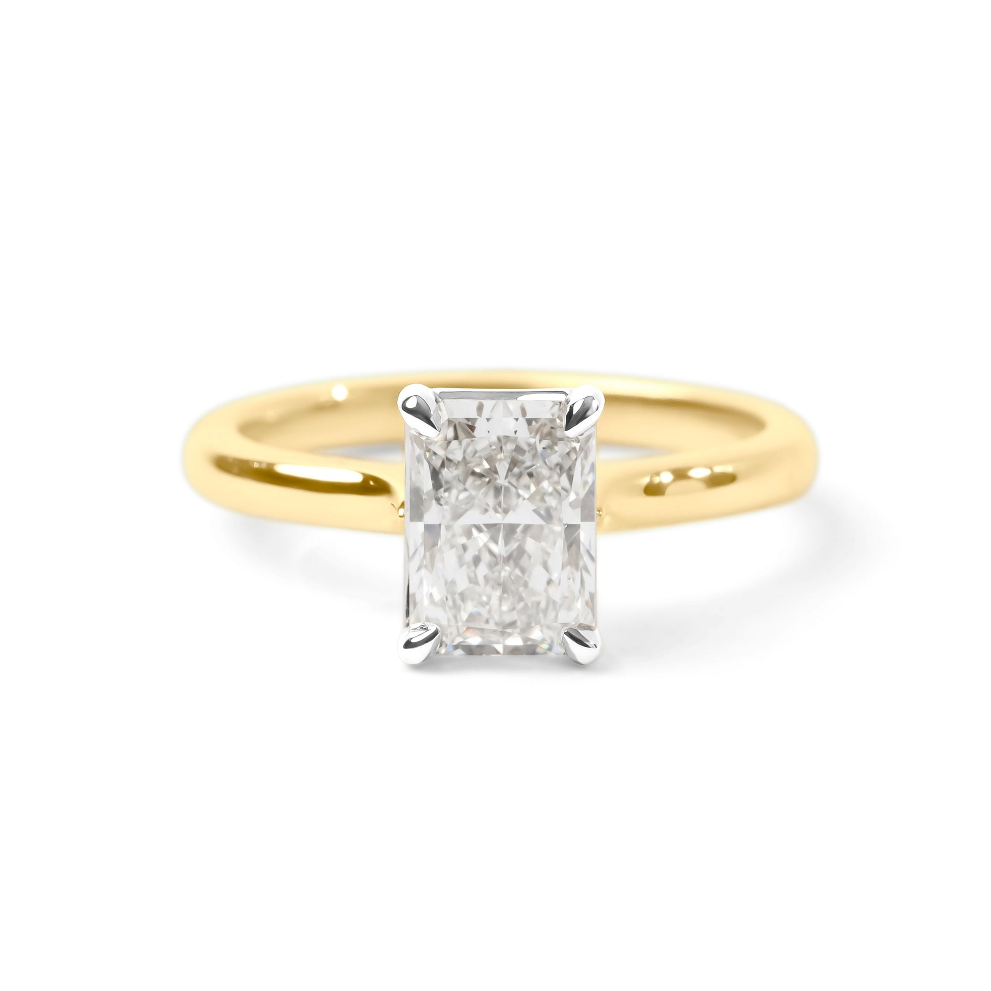 A classic solitaire engagement ring featuring a rectangular radiant-cut diamond set in a yellow gold band with a silver-colored prong setting, shown on a clean white background.