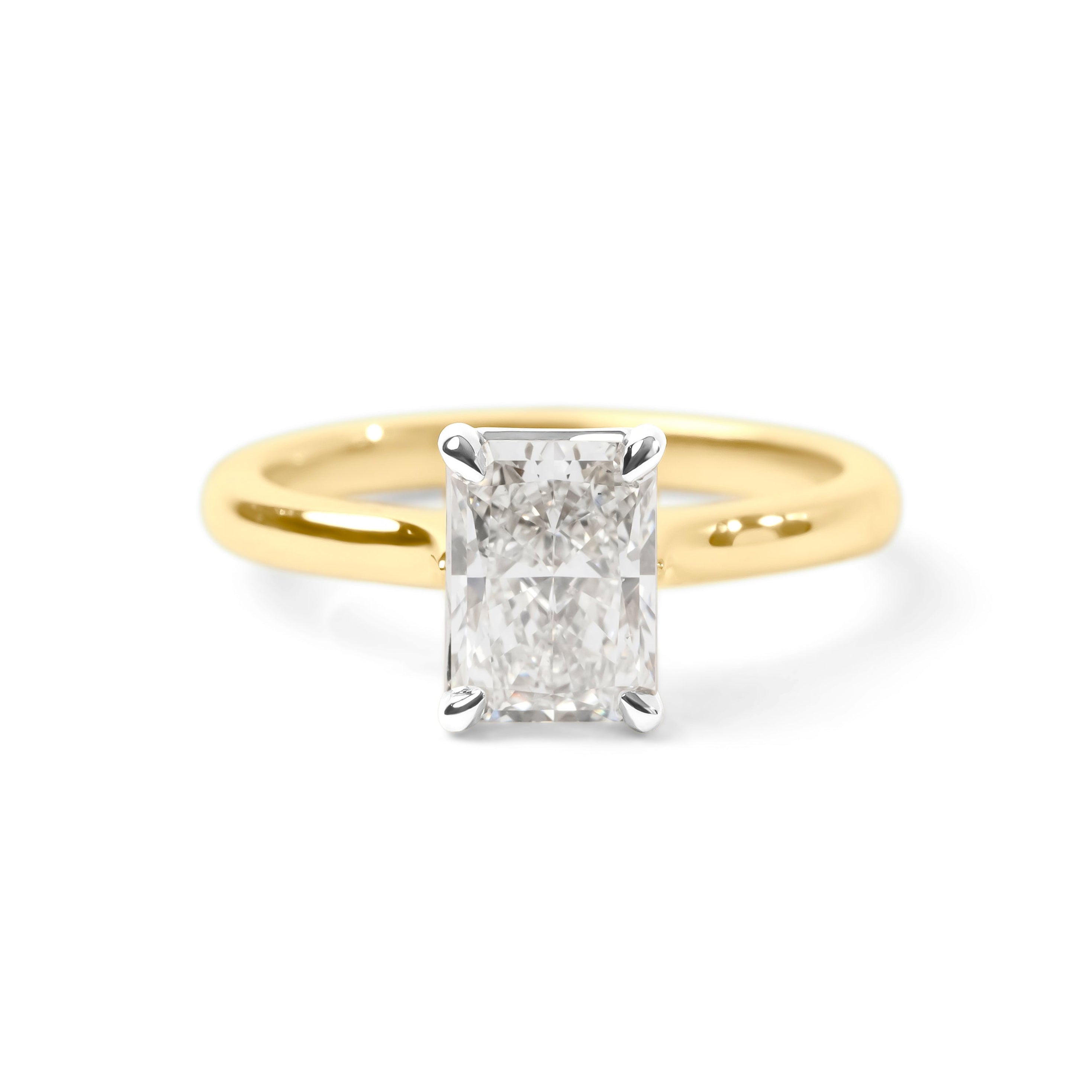 A classic solitaire engagement ring featuring a rectangular radiant-cut diamond set in a yellow gold band with a silver-colored prong setting, shown on a clean white background.