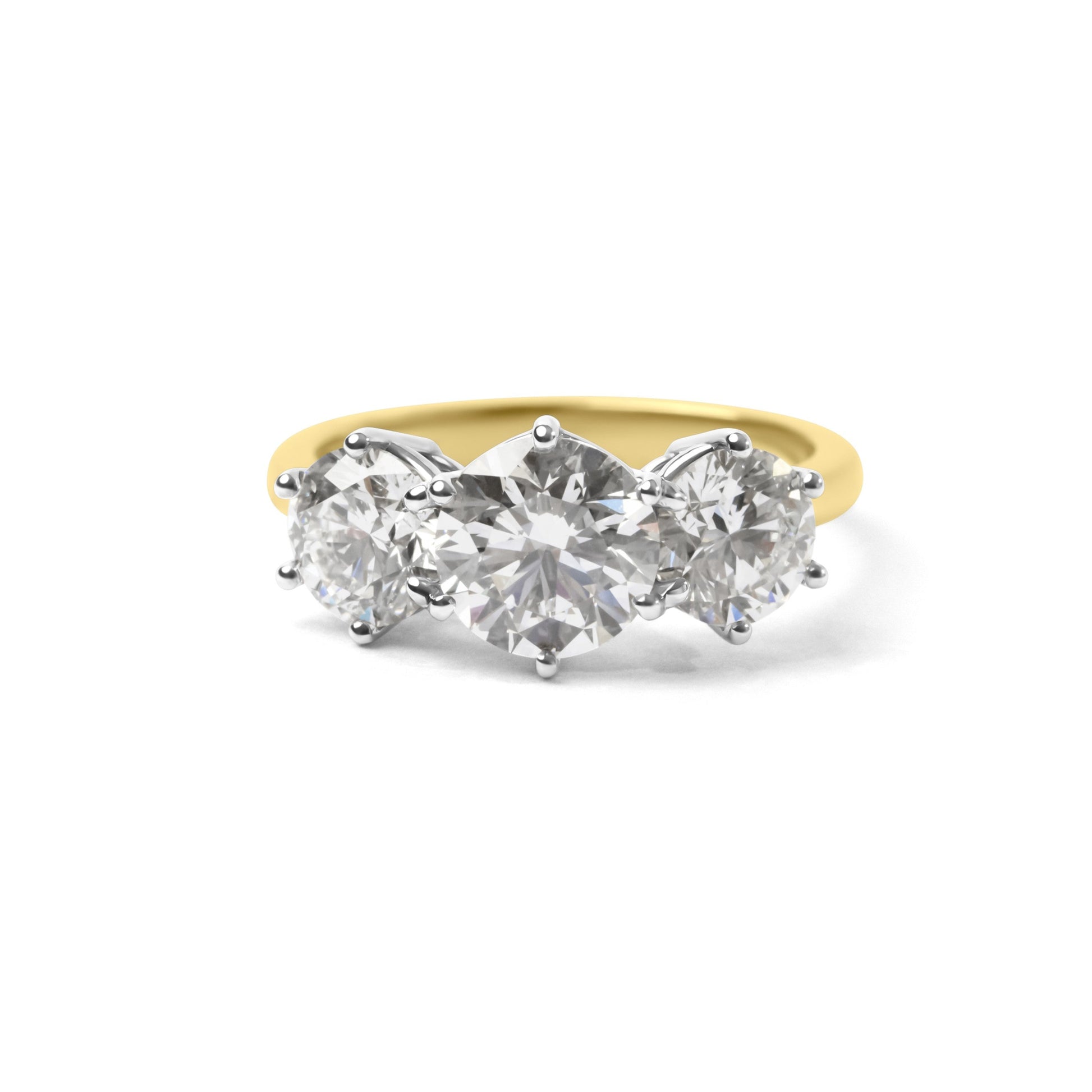 A three-stone diamond ring with a yellow gold band and silver-colored prongs, set against a plain white background.